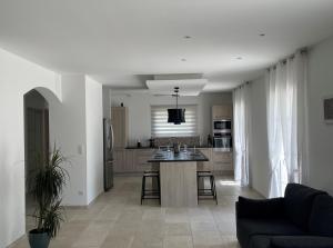 a kitchen and living room with a couch and a table at La Bastide Cezanne Natural elegance in Aix-en-Provence