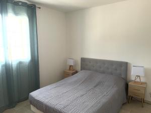 a bedroom with a bed and a window and two lamps at La Bastide Cezanne Natural elegance in Aix-en-Provence
