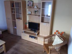 ein Wohnzimmer mit einem TV und einem Stuhl in der Unterkunft Ferìenwohnung Mende 1 in Lübbenau