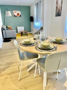 Grace cosy في Villers-lès-Nancy: غرفة طعام مع طاولة مع أطباق وكراسي