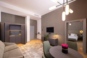 a living room with a couch and a table and a bed at VIS Urban Suites&Spa in Bari