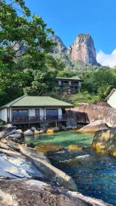 a resort on a river with a mountain in the background at Minang Cove Resort in Tioman Island