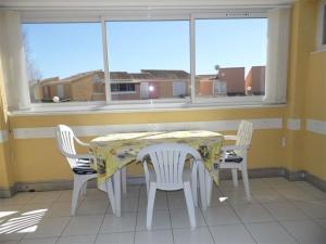 einen Tisch und Stühle in einem Zimmer mit Fenster in der Unterkunft Appartement Marseillan-Plage, 2 pièces, 4 personnes - FR-1-326-478 in Marseillan
