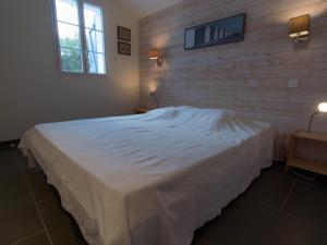 バンゴールにあるMaison Bangor, 5 pièces, 8 personnes - FR-1-418-6の白いベッドとレンガの壁が備わるベッドルーム1室が備わります。
