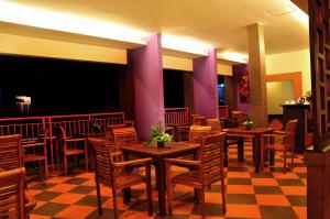 une salle à manger avec des tables et des chaises en bois dans l'établissement Guest House Matahari, à Kuta