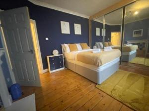 um quarto com uma cama grande e um espelho em Irongray House em Glasgow
