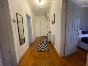 a hallway with a room with a bed and a rug at Irongray House in Glasgow
