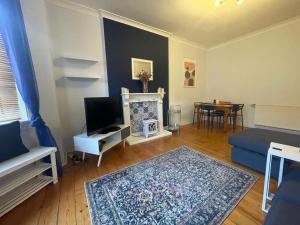 - un salon avec un canapé bleu et une cheminée dans l'établissement Irongray House, à Glasgow