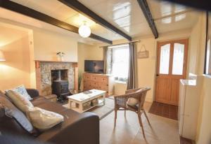 a living room with a couch and a fireplace at Water's View Cottage, Hayle in Hayle