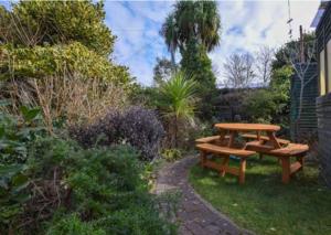 einem Picknicktisch und einer Bank im Garten in der Unterkunft Water's View Cottage, Hayle in Hayle