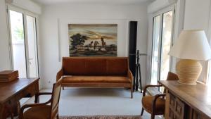 a living room with a couch and a painting on the wall at Loustalou in Saint-Tropez
