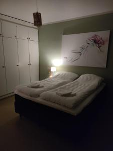 a large bed in a bedroom with a lamp at Villa Astrid in Pietarsaari