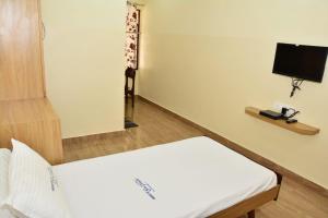 Camera con letto e TV a schermo piatto. di Hotel Sree Vasudev a Vijayawāda