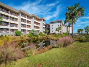 un hôtel avec un étang en face d'un bâtiment dans l'établissement Beach & Tennis Admirals Row 105, 1 Bedroom, Sleeps 6, Ocean Front, 2 Pools, Tennis, à Île de Hilton-Head