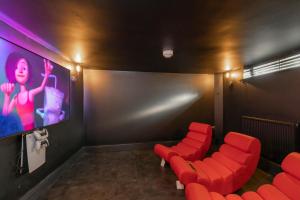 a cinema room with red chairs and a screen at Elliot Oliver - Laverham House - Stunning 6 Bedroom Regency House With Parking in Cheltenham
