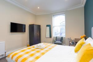 ein Schlafzimmer mit einem Bett und einem TV an der Wand in der Unterkunft Royal 2bed apartment City Center in Edinburgh