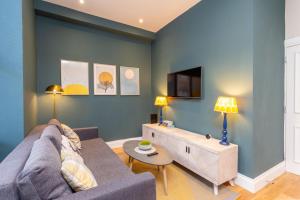 uma sala de estar com um sofá e uma televisão em Royal 2bed apartment City Center em Edinburgo