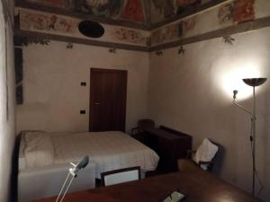 1 dormitorio con cama, escritorio y mesa en Palazzo cinquecentesco con giardino interno, en Verona