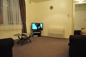 a living room with a table and a flat screen tv at GreenGate Cottages in Strahan