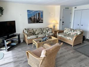 a living room with couches and a flat screen tv at Thunder Island 157D condo in Ocean City