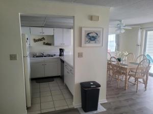 een keuken en eetkamer met een tafel en stoelen bij Thunder Island 157D condo in Ocean City