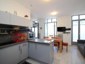 a kitchen with white cabinets and a living room at Charmant T3 en centre-ville - 2 chambres - 42m² - Balconnets - Résidence avec ascenseur - 4 pers. - FR-1-608-164 in La Bourboule