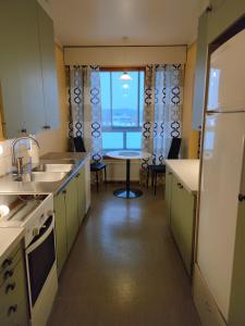 eine Küche mit einem großen Fenster und einem Tisch mit Stühlen in der Unterkunft Villa Astrid in Pietarsaari