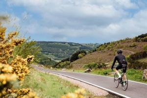 a man riding a bike down a road at Newly renovated, hi-spec three bed, forest view home in Cwmcarn