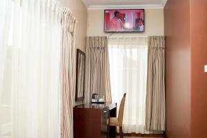 a room with a desk and a television on the wall at Krisstar Lodge in Blantyre