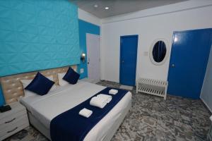 um quarto com uma cama grande e paredes azuis em Paradise Village Beach Resort em Calangute
