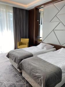 Pokój hotelowy z 2 łóżkami i krzesłem w obiekcie Hotel Falko w mieście Rumia