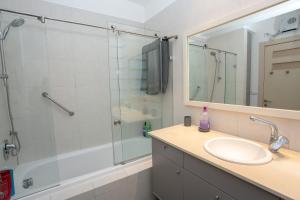 a bathroom with a shower and a sink and a mirror at 9 Sderot Chen - By Beach Apartments TLV in Tel Aviv