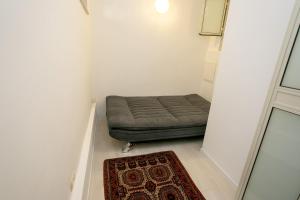 a small room with a bed in a room with a rug at 9 Sderot Chen - By Beach Apartments TLV in Tel Aviv