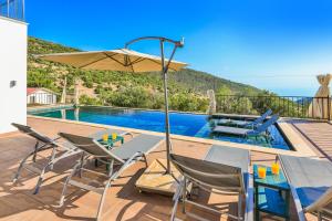 a pool with a table and chairs and an umbrella at Villa mirador in Kas
