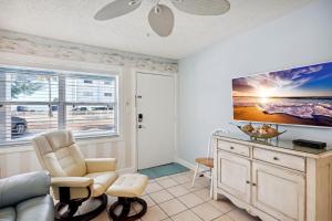 ein Wohnzimmer mit einem Sofa und einem TV in der Unterkunft Harbor House 37 in St Pete Beach