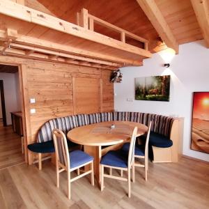 a dining room with a wooden table and chairs at Haus Hubertus in Hochfilzen
