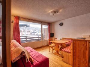 ein Wohnzimmer mit einem Tisch und einem großen Fenster in der Unterkunft Appartement Morillon 1100, 2 pièces, 6 personnes - FR-1-642-79 in Morillon