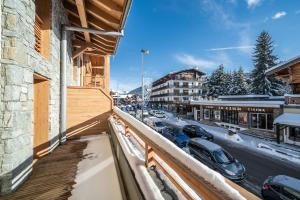 a balcony of a building with cars parked on the street at Apartment Kanoko Les Gets- BY EMERALD STAY in Les Gets