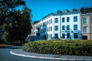 duży biały budynek z krzakiem przed nim w obiekcie Hotel Filip w Oslo