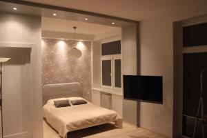 um quarto com uma cama e uma televisão de ecrã plano em Kaunas Center Apartments - K. Mindaugo g. em Kaunas