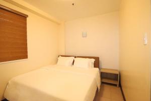 a white bed in a room with a window at Leo Hotel in Baguio