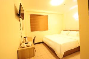 a hotel room with a bed and a window at Leo Hotel in Baguio