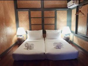 a bedroom with two beds with stuffed elephants on them at Bann Pae Cabana Hotel And Resort in Klaeng