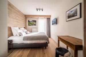 1 dormitorio con cama y escritorio de madera en Apartment Kanoko Les Gets- BY EMERALD STAY, en Les Gets