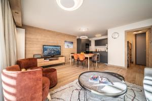a living room with a table and chairs at Apartment Kanoko Les Gets- BY EMERALD STAY in Les Gets