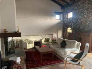 sala de estar con sofá blanco y chimenea en Al vecchio fienile en Fagagna