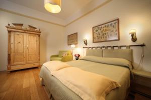 a bedroom with two beds and a chair in it at Residenza Le 6 A in Trieste