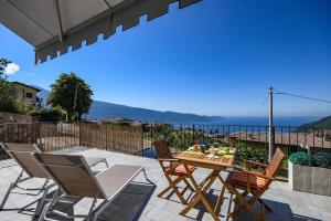 ティニャーレにあるAppartamenti Castello Resortの海を望むパティオ(テーブル、椅子付)