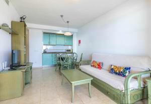 ein Wohnzimmer mit einem Sofa und einem Tisch in der Unterkunft Inftour Amatista 10 Apartamento in Calpe