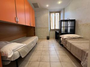 a room with two beds and a cabinet at Be Your Home - Casa Vacanze Il Conservatorio in Civitavecchia